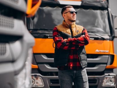 Handsome man truck driver standing by the truck